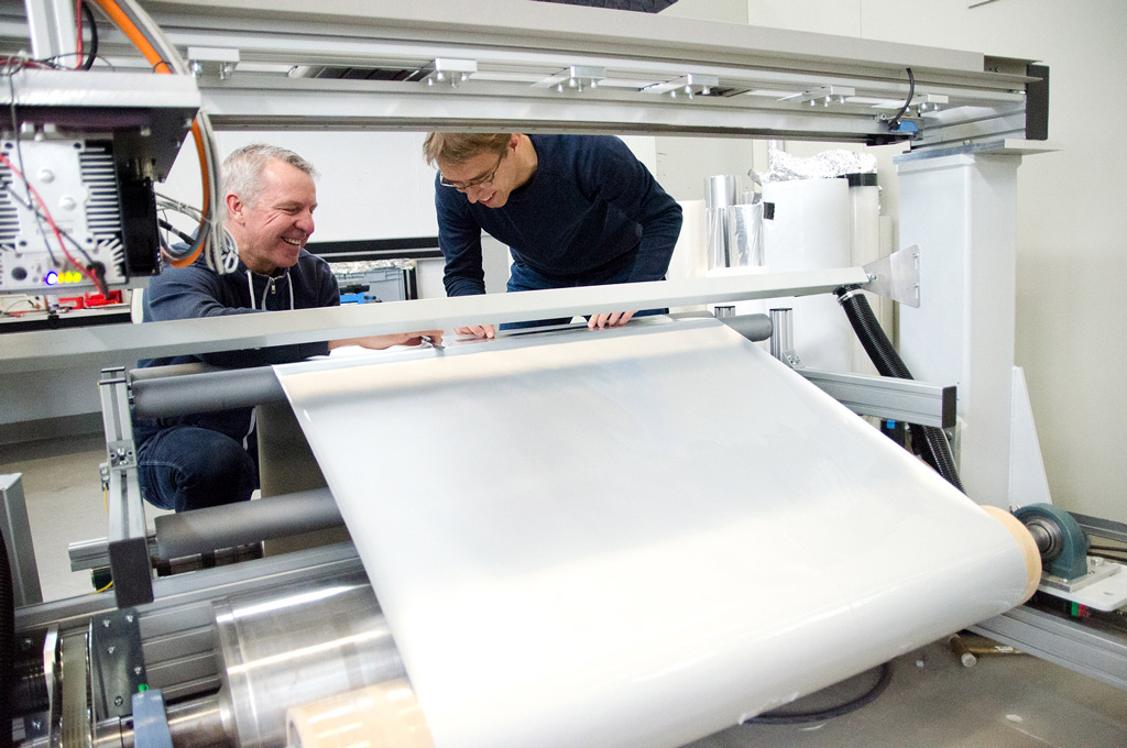 Zwei Männer vor der Folierungsmaschine