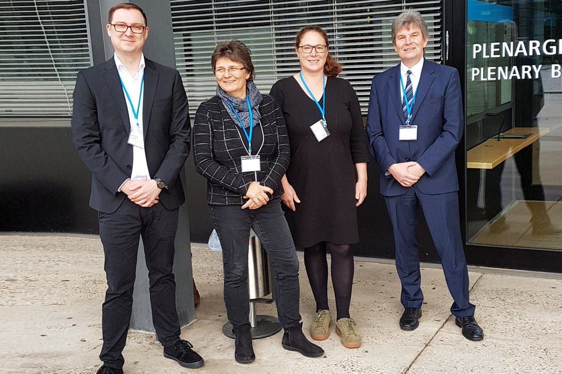 Matthias Joswig (RUB), Martina Kunzendorf (HS Gesundheit), Prof. Dr. Annette Bernloehr (HS Gesundheit) und Prof. Dr. med. Thorsten Schäfer (RUB) vor dem ehemaligen Plenarsaal des Deutschen Bundestages in Bonn.