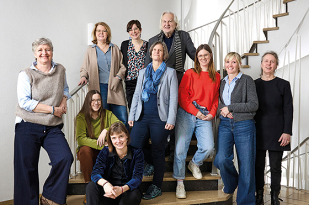 Das Propjektteam, bestehend aus 10 Personen, steht an Ansatz einer Wendeltreppe und alle blicken lächelnd in die Kamera.